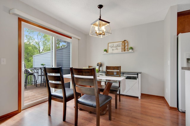 5133 Farnham Dr N, Hugo, MN 55038 - dining area with a chandelier, wood finished floors, and baseboards