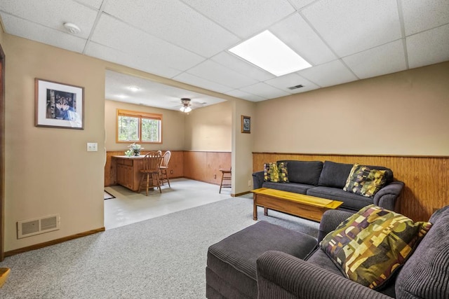 2511 Carver Ave E, Maplewood, MN 55119 - carpeted living area featuring a bar, a paneled ceiling, wainscoting, wood walls, and baseboards
