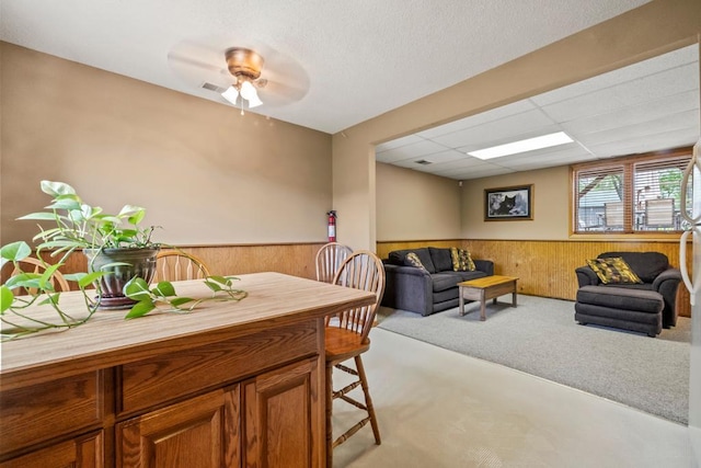 2511 Carver Ave E, Maplewood, MN 55119 - carpeted living area with wainscoting, wooden walls, and a ceiling fan
