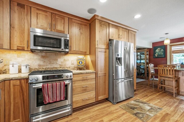 2511 Carver Ave E, Maplewood, MN 55119 - kitchen featuring stainless steel appliances, light wood finished floors, tasteful backsplash, light stone countertops, and recessed lighting