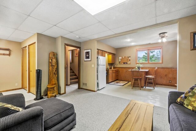 2511 Carver Ave E, Maplewood, MN 55119 - living room featuring a drop ceiling, stairs, and light colored carpet