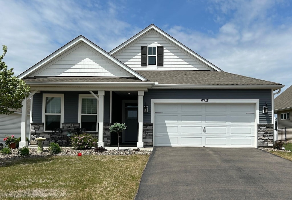 13615 Applewood Trl, Rosemount, MN 55068 - view of front of property featuring stone siding, asphalt driveway, a porch, and a front lawn