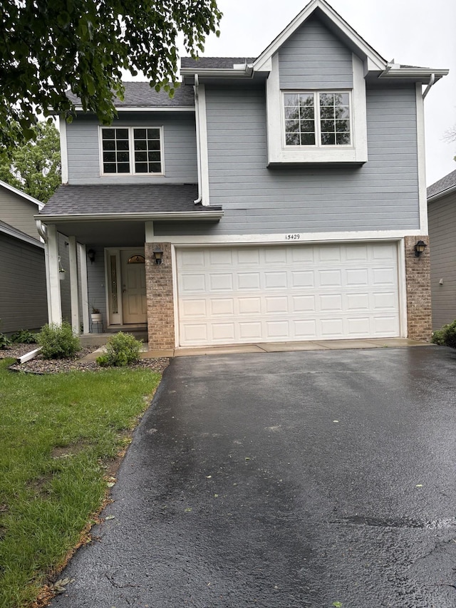15429 Sussex Dr, Minnetonka, MN 55345 - traditional-style house with a garage, driveway, brick siding, and a shingled roof