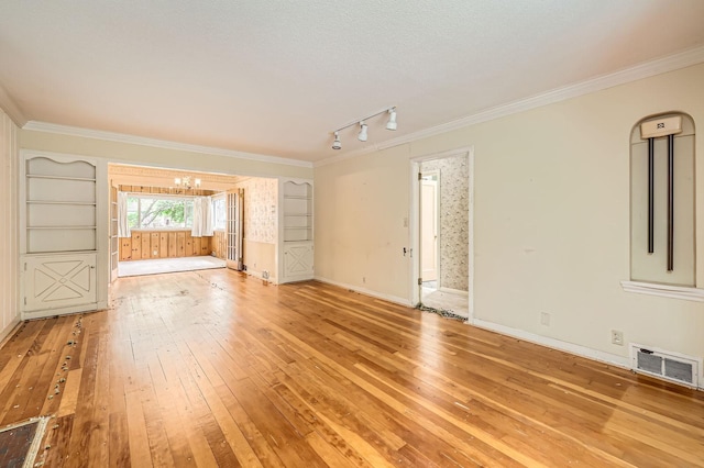 7029 Augsburg Ave S, Richfield, MN 55423 - empty room featuring light wood-style floors, a chandelier, track lighting, crown molding, and baseboards