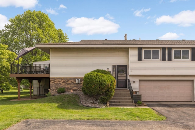 4119 Sylvia Ln S, Shoreview, MN 55126 - view of front facade featuring a garage, brick siding, a front yard, asphalt driveway, and a wooden deck