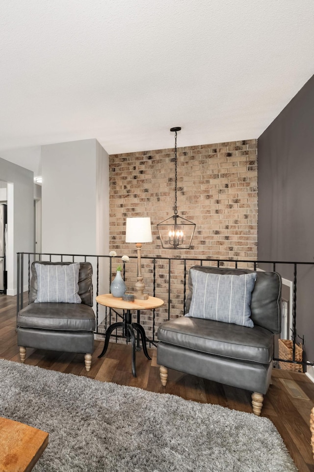 4119 Sylvia Ln S, Shoreview, MN 55126 - living room with brick wall, a chandelier, wood finished floors, and baseboards