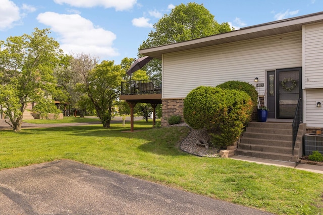 4119 Sylvia Ln S, Shoreview, MN 55126 - view of home's exterior featuring central air condition unit, a lawn, a wooden deck, and brick siding