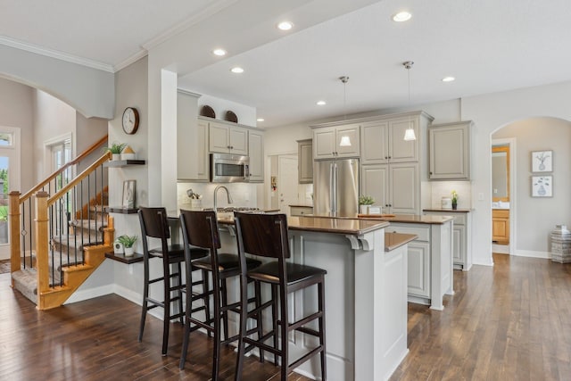11560 Ashley Ct, Inver Grove Heights, MN 55077 - kitchen featuring appliances with stainless steel finishes, arched walkways, a peninsula, backsplash, and dark wood-style floors