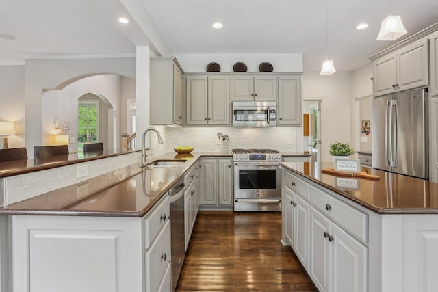 11560 Ashley Ct, Inver Grove Heights, MN 55077 - kitchen featuring stainless steel appliances, a sink, arched walkways, tasteful backsplash, and dark wood finished floors