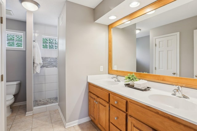 11560 Ashley Ct, Inver Grove Heights, MN 55077 - bathroom with toilet, a tile shower, double vanity, baseboards, and tile patterned floors