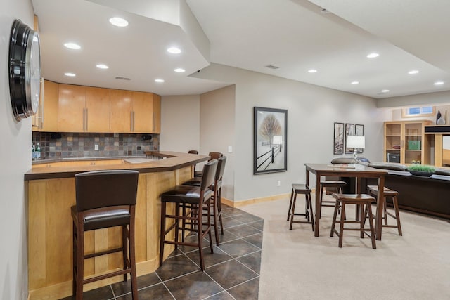 11560 Ashley Ct, Inver Grove Heights, MN 55077 - kitchen featuring recessed lighting, tasteful backsplash, a kitchen breakfast bar, dark tile patterned flooring, and baseboards