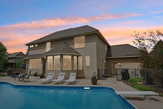 11560 Ashley Ct, Inver Grove Heights, MN 55077 - back of house at dusk with a patio area and a shingled roof