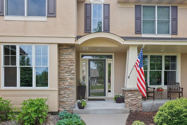 11560 Ashley Ct, Inver Grove Heights, MN 55077 - view of exterior entry with stone siding, covered porch, and stucco siding
