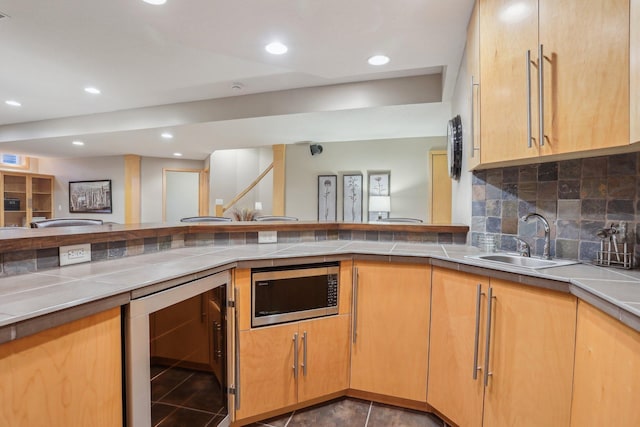 11560 Ashley Ct, Eagan, MN 55077 - kitchen with wine cooler, stainless steel microwave, a sink, tasteful backsplash, and tile counters
