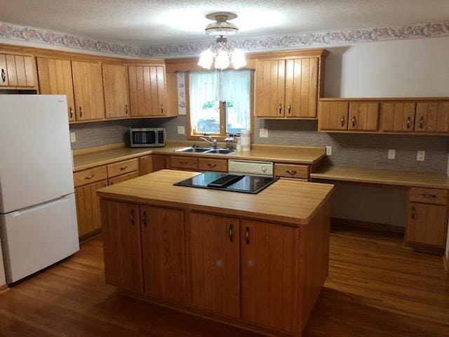 2023 Woodcrest Ln SW, Rochester, MN 55902 - kitchen with white appliances, a sink, wood finished floors, a center island, and decorative backsplash