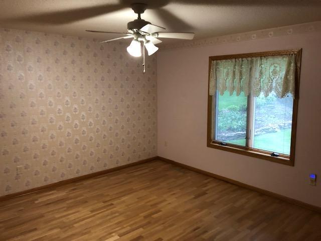 2023 Woodcrest Ln SW, Rochester, MN 55902 - unfurnished room with wood finished floors, baseboards, and a ceiling fan