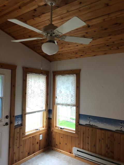 2023 Woodcrest Ln SW, Rochester, MN 55902 - unfurnished room featuring baseboard heating, plenty of natural light, ceiling fan, wooden ceiling, and wainscoting