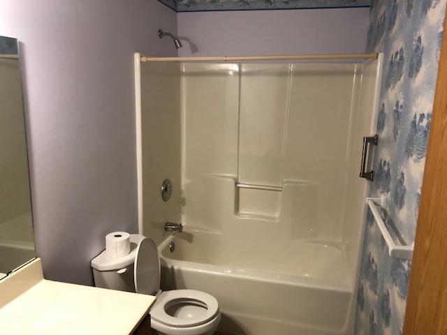 2023 Woodcrest Ln SW, Rochester, MN 55902 - bathroom with vanity, washtub / shower combination, and toilet