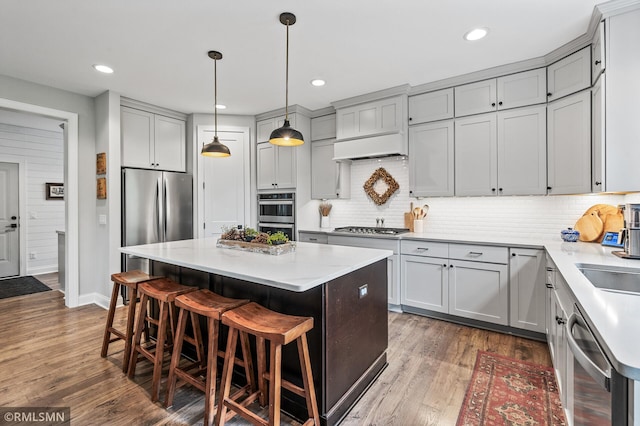 7023 61st St S, Cottage Grove, MN 55016 - kitchen with stainless steel appliances, a kitchen island, tasteful backsplash, a kitchen bar, and light countertops