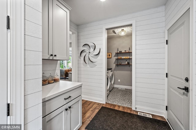7023 61st St S, Cottage Grove, MN 55016 - kitchen featuring washing machine and dryer, dark wood finished floors, light countertops, and wood walls