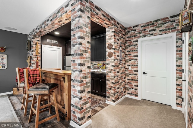 7023 61st St S, Cottage Grove, MN 55016 - indoor dry bar featuring freestanding refrigerator, baseboards, brick wall, and carpet