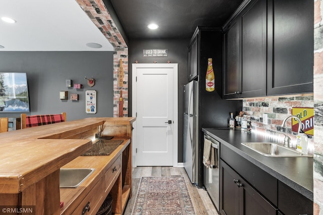 7023 61st St S, Cottage Grove, MN 55016 - kitchen with a sink, appliances with stainless steel finishes, light wood-type flooring, tasteful backsplash, and dark cabinetry