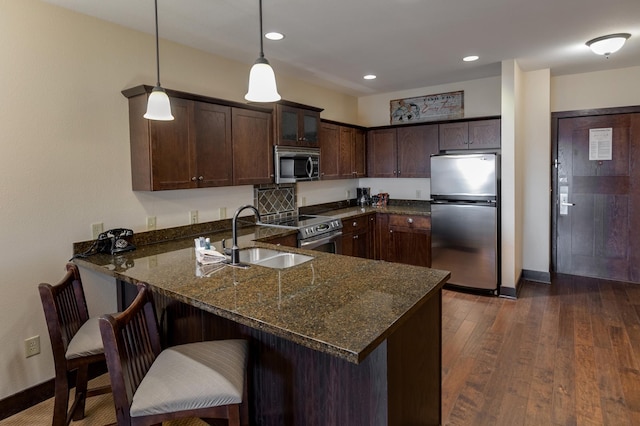 502 Cleveland Blvd W Unit 2400, Walker, MN 56484 - kitchen featuring appliances with stainless steel finishes, a sink, a peninsula, dark stone counters, and dark brown cabinets