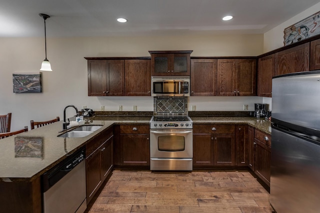 502 Cleveland Blvd W Unit 2400, Walker, MN 56484 - kitchen with stainless steel appliances, a sink, dark brown cabinetry, decorative light fixtures, and light wood-style flooring