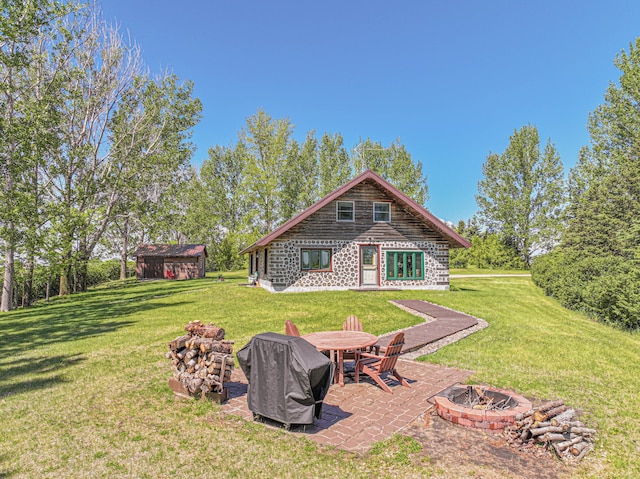 12926 Daisy Ln SW, Farwell, MN 56327 - view of green lawn with a fire pit, a patio, and an outdoor structure