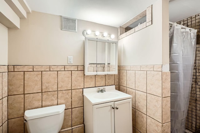 900 Charles Ave, Saint Paul, MN 55104 - full bath with tile walls, vanity, toilet, a tile shower, and a wainscoted wall