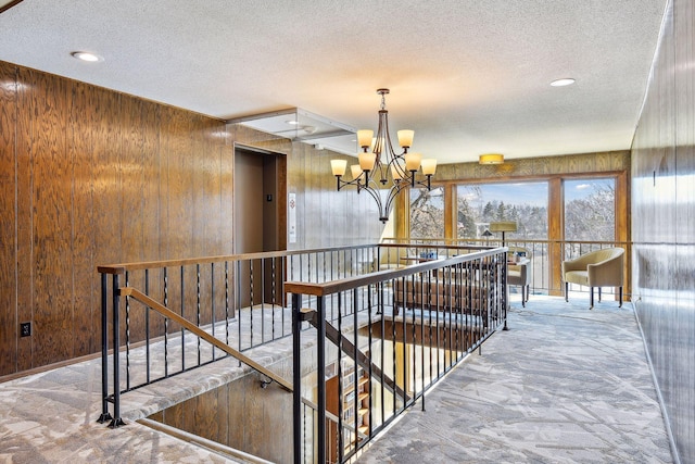 4360 Brookside Ct Unit 305, Edina, MN 55436 - corridor featuring an upstairs landing, a textured ceiling, a chandelier, recessed lighting, and wood walls