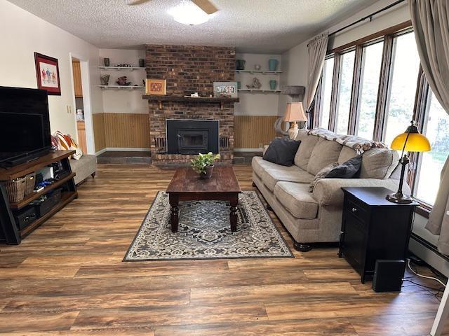 22 Cottonwood Ct, Babbitt, MN 55706 - living area featuring a textured ceiling, healthy amount of natural light, wood finished floors, a ceiling fan, and wainscoting