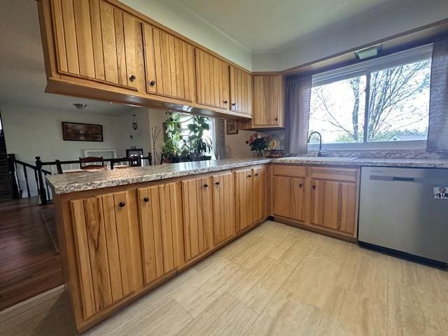 22 Cottonwood Ct, Babbitt, MN 55706 - kitchen featuring stainless steel dishwasher, a sink, a peninsula, and brown cabinets