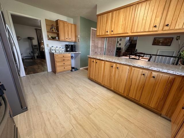 22 Cottonwood Ct, Babbitt, MN 55706 - kitchen with open shelves, light wood-style flooring, and brown cabinetry