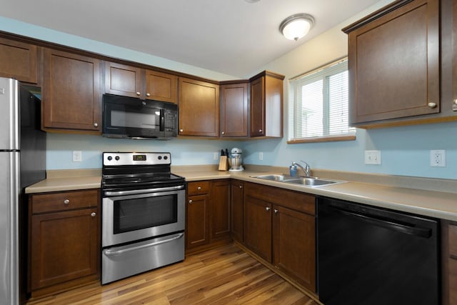 105 Owl Path, Mankato, MN 56001 - kitchen with black appliances, a sink, light wood-type flooring, light countertops, and dark brown cabinetry