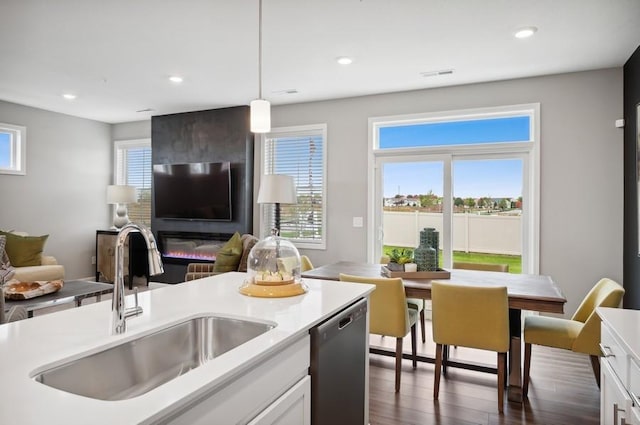 2154 Tyrone Dr, Shakopee, MN 55379 - kitchen featuring a sink, stainless steel dishwasher, white cabinetry, hanging light fixtures, and light countertops