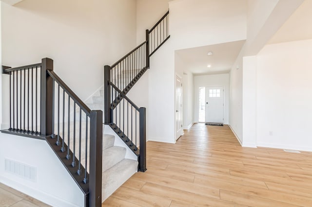 6743 Tamarack Ln, Corcoran, MN 55340 - foyer featuring light wood-type flooring, baseboards, stairway, a high ceiling, and recessed lighting
