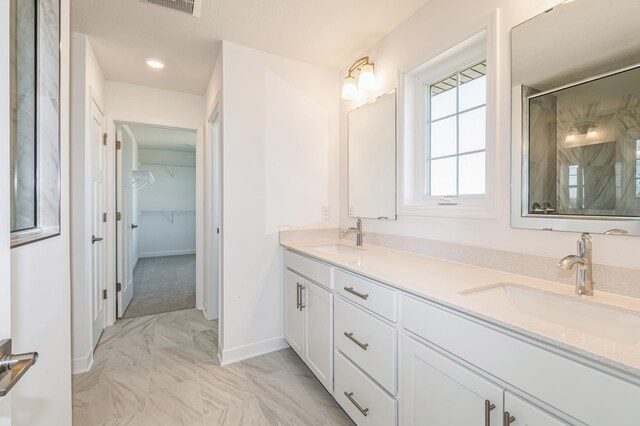 6743 Tamarack Ln, Corcoran, MN 55340 - bathroom featuring marble look tiles, a shower stall, double vanity, baseboards, and a walk in closet