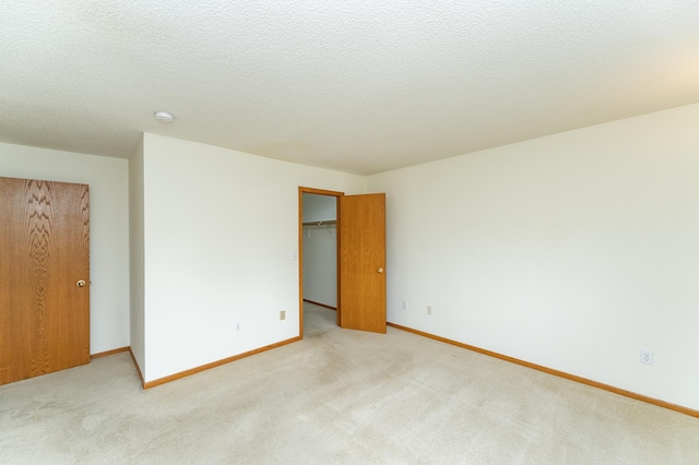 2225 Fisher Ct NW, Rochester, MN 55901 - unfurnished bedroom featuring light colored carpet, a spacious closet, a closet, and a textured ceiling