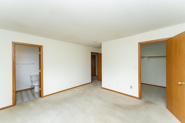 2225 Fisher Ct NW, Rochester, MN 55901 - unfurnished bedroom featuring a walk in closet, light colored carpet, connected bathroom, and a closet
