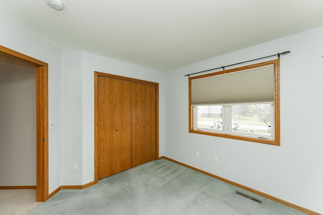 2225 Fisher Ct NW, Rochester, MN 55901 - unfurnished bedroom with a closet, carpet floors, and a textured ceiling