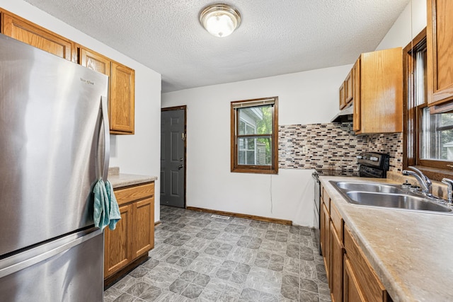 917 Jessie St, Saint Paul, MN 55130 - kitchen featuring freestanding refrigerator, range, a textured ceiling, light countertops, and under cabinet range hood