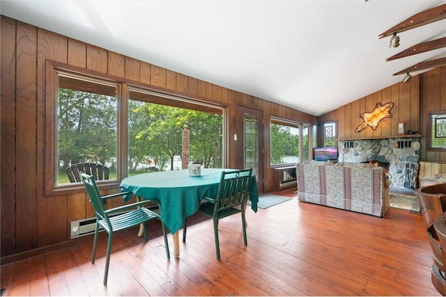 20907 Erickson Ln, Trade Lake, WI 54840 - dining space with wood walls, vaulted ceiling, hardwood / wood-style floors, and a fireplace
