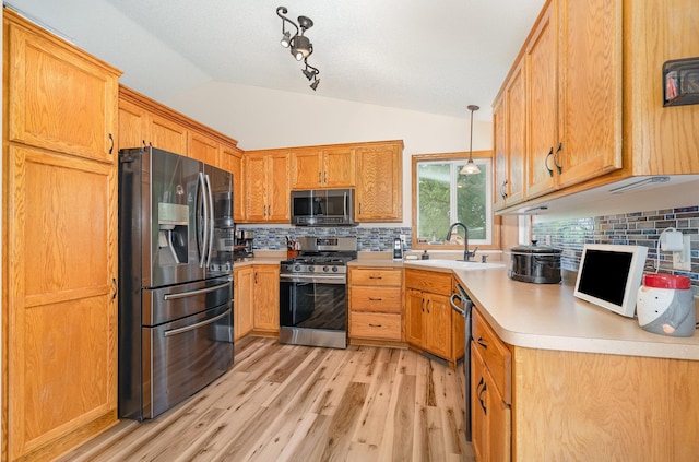 509 8th Ave SE, Isanti, MN 55040 - kitchen featuring appliances with stainless steel finishes, a sink, light wood-style flooring, backsplash, and lofted ceiling