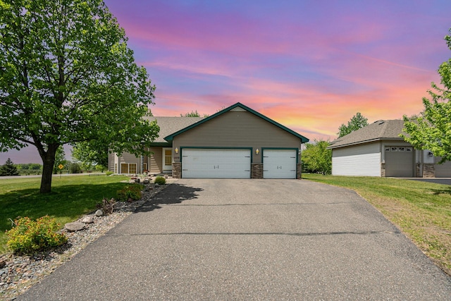 509 8th Ave SE, Isanti, MN 55040 - ranch-style home featuring a front yard, a garage, asphalt driveway, stone siding, and roof with shingles