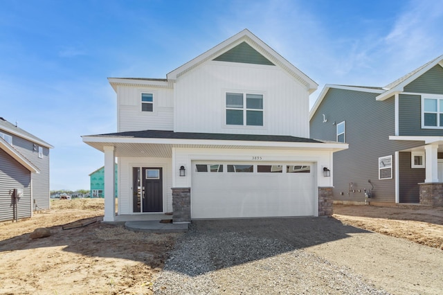 view of front of house with dirt driveway, stone siding, and a garage