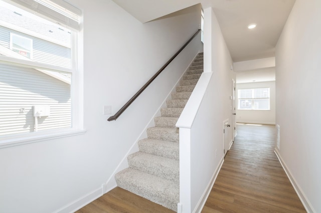 stairway with wood finished floors and baseboards