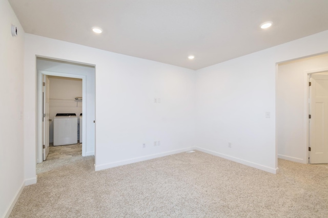 empty room featuring washer / clothes dryer, light colored carpet, baseboards, and recessed lighting