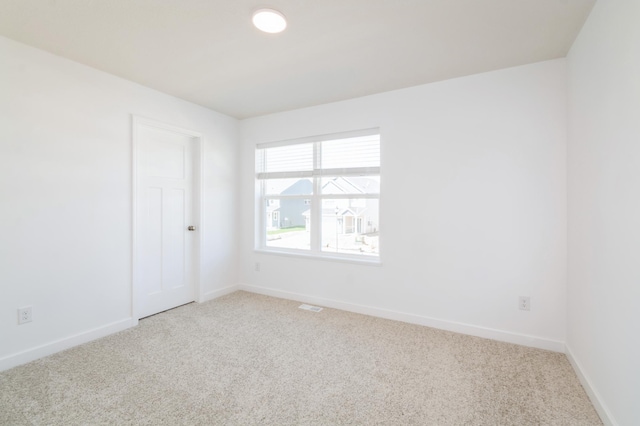 carpeted empty room featuring baseboards