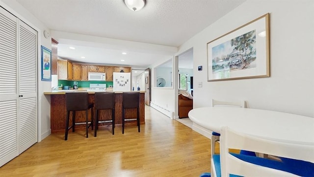 13993 Crosstown Blvd NW, Andover, MN 55304 - kitchen featuring white appliances, light wood-type flooring, light countertops, a peninsula, and recessed lighting